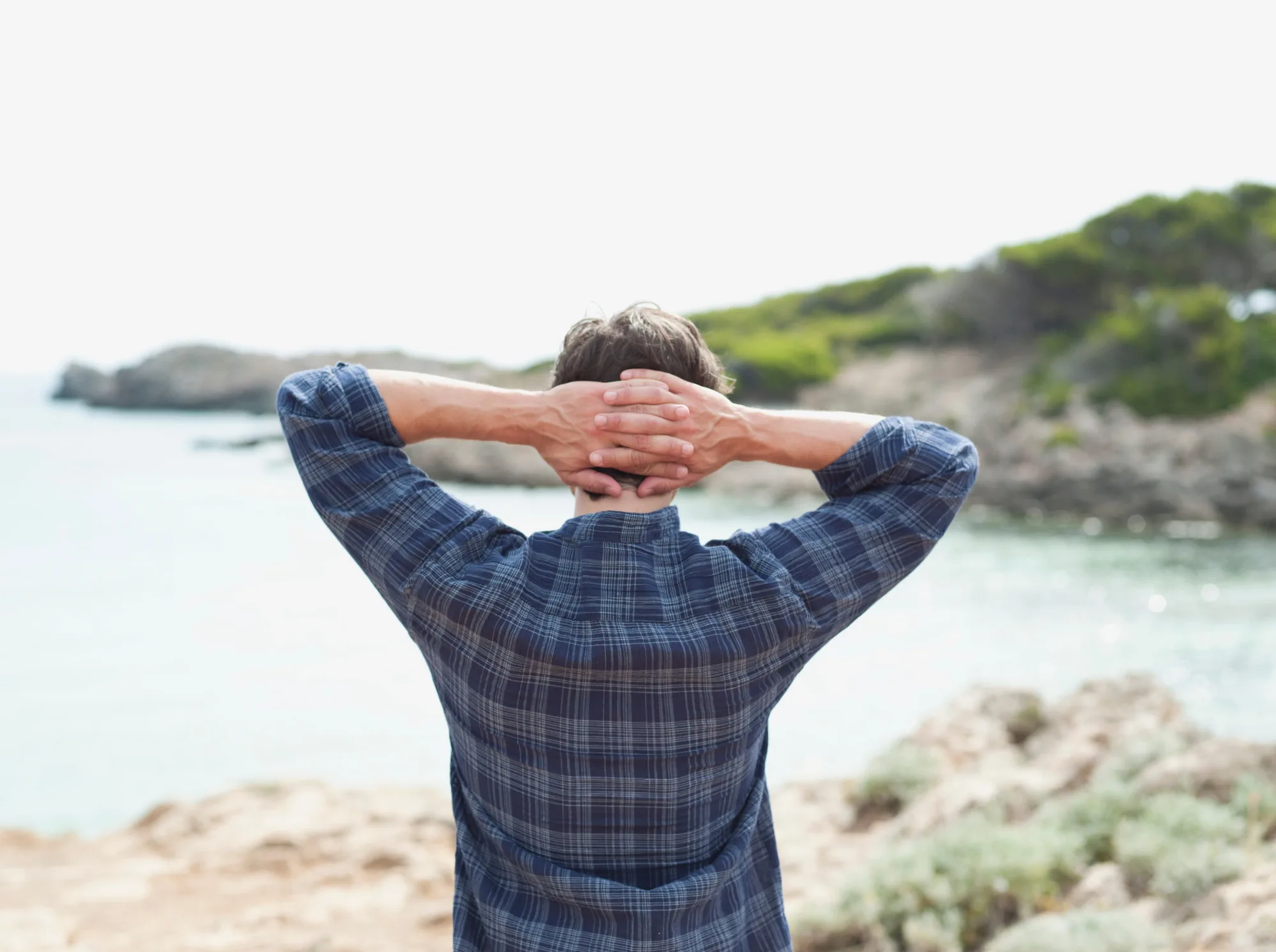 man looking at coastline